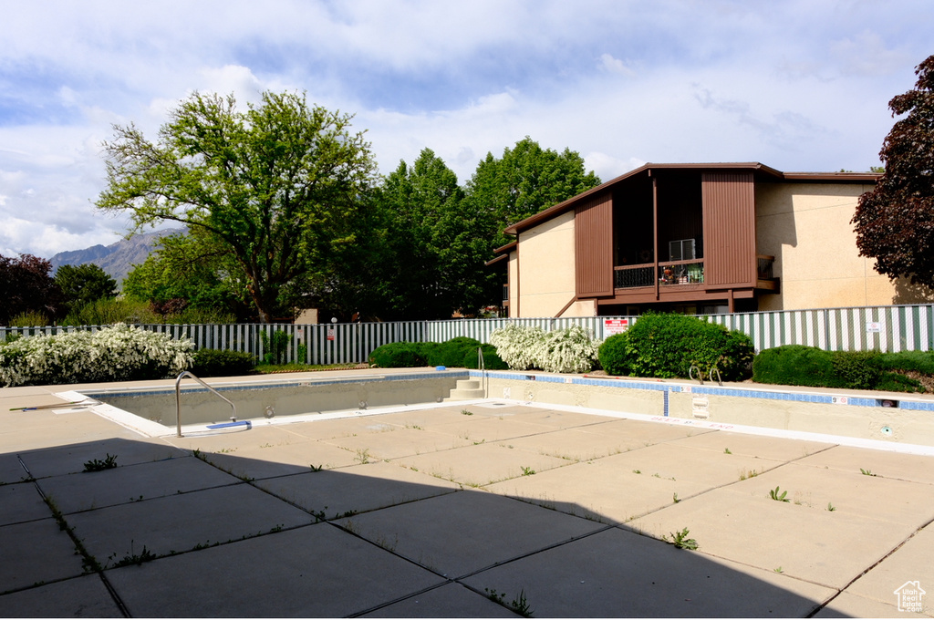 View of pool featuring fence, a patio area, and a mountain view