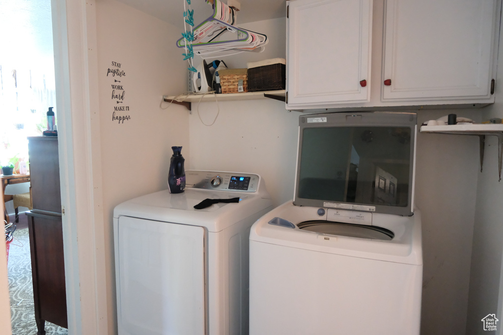 Laundry room featuring separate washer and dryer and cabinet space