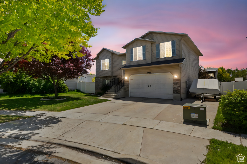 View of front of home featuring an attached garage, driveway, and stone siding