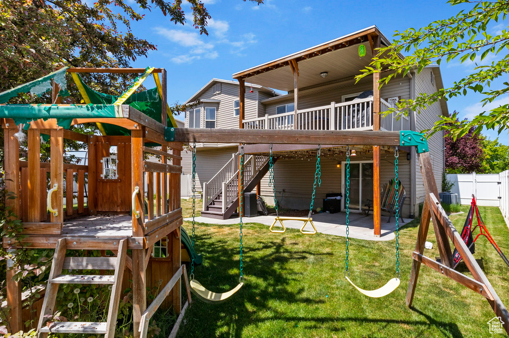 Back of property featuring a playground, a patio area, cooling unit, a deck, and stairs