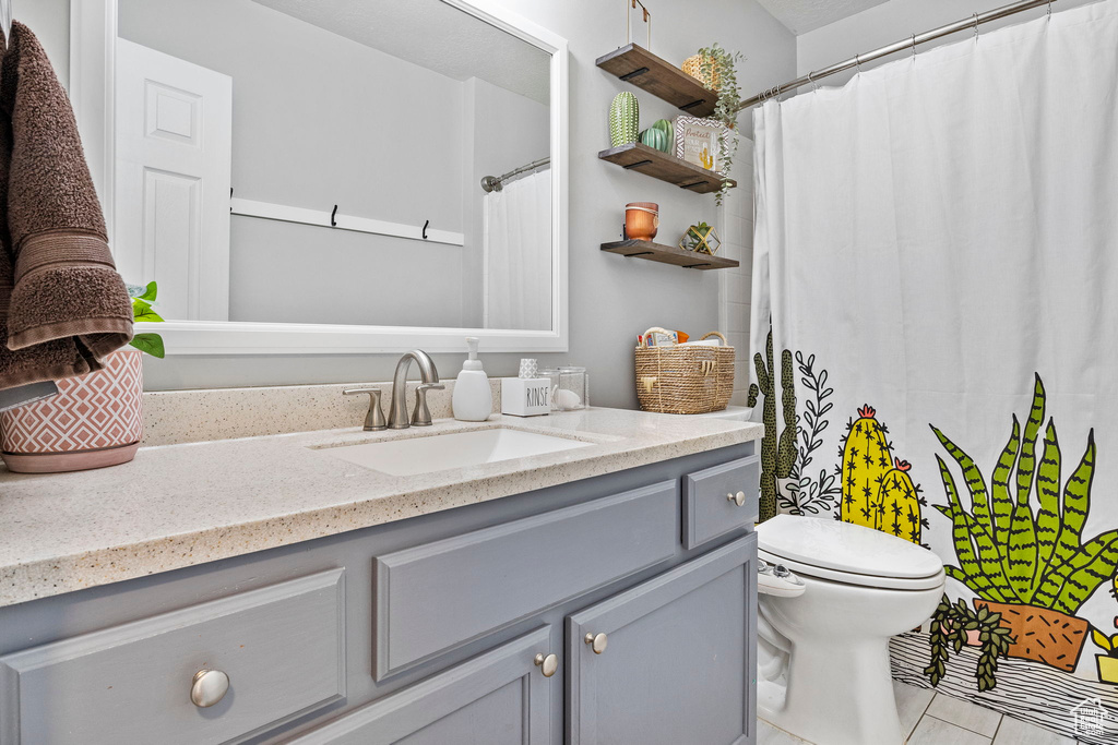 Full bath featuring vanity, toilet, tile patterned flooring, and a shower with shower curtain