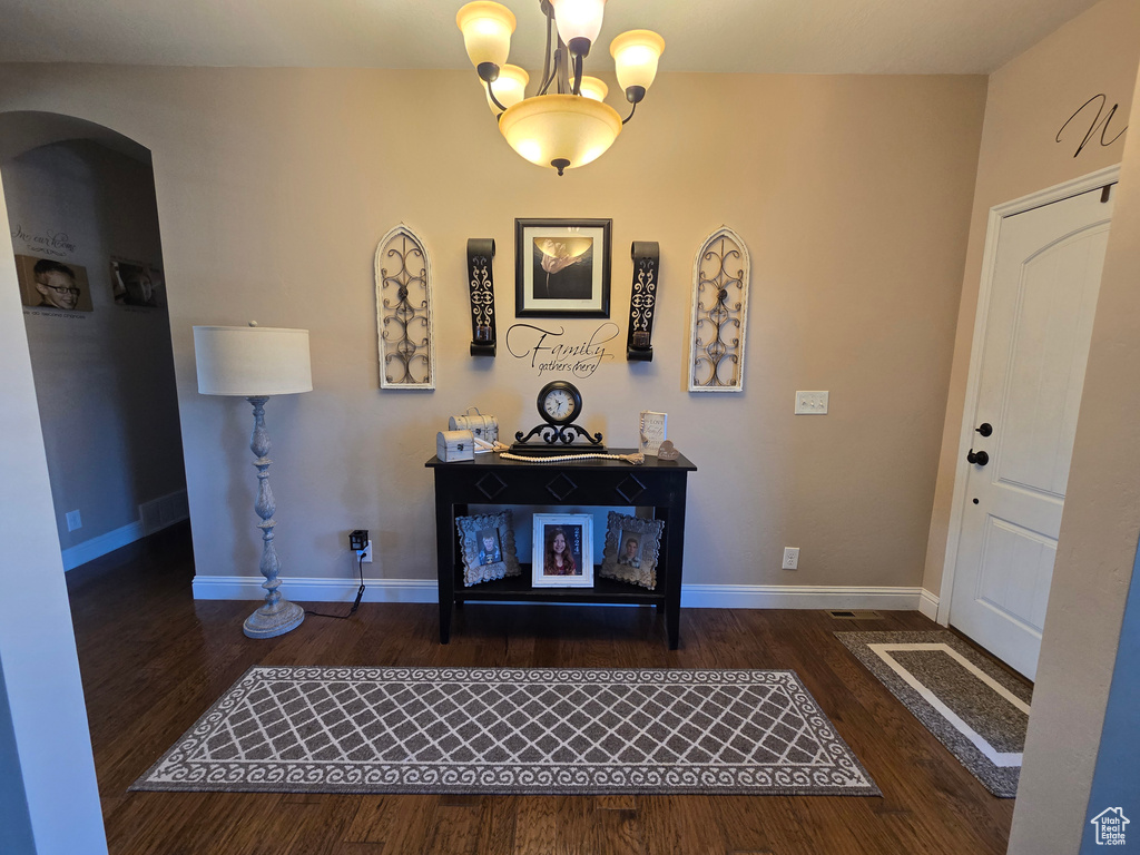 Entrance foyer featuring arched walkways, wood finished floors, and baseboards