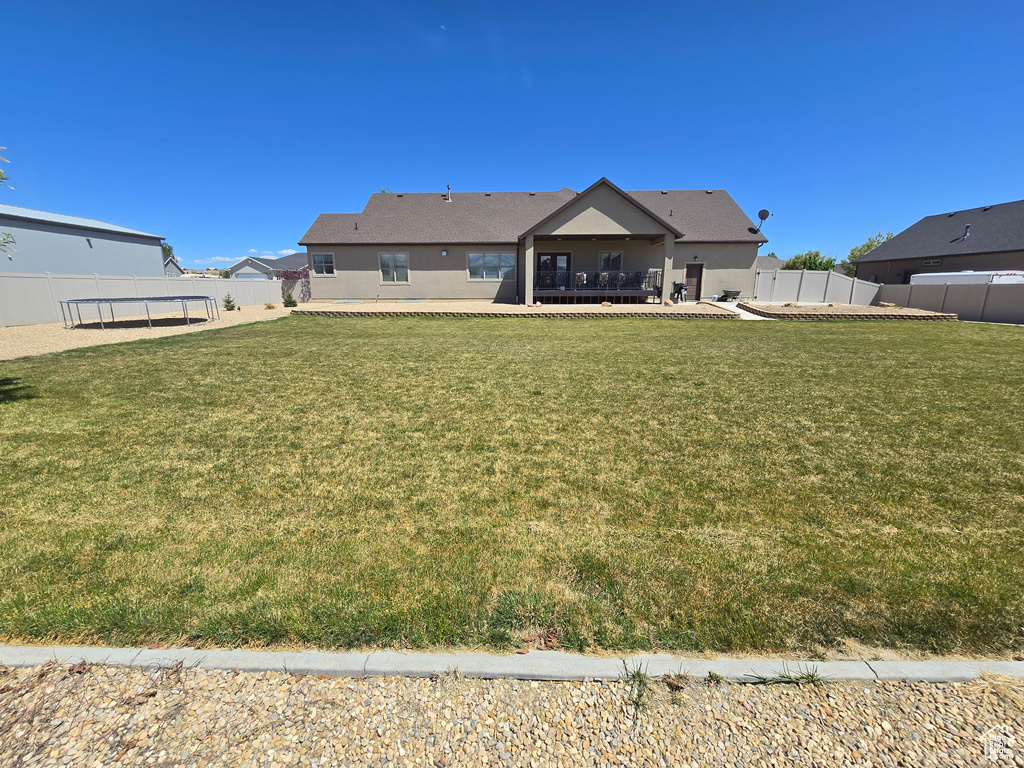 Rear view of property featuring a trampoline