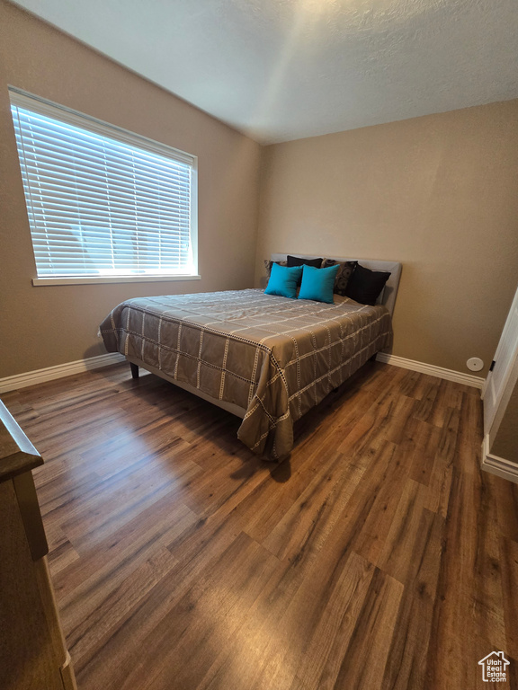 Bedroom with wood finished floors and baseboards