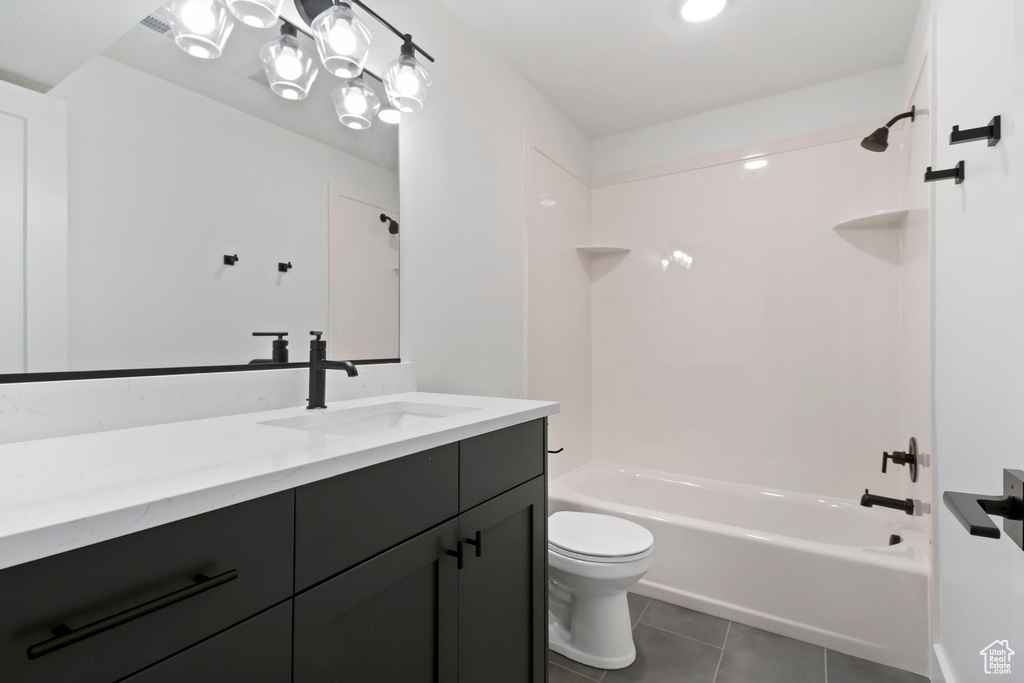 Bathroom featuring tile patterned floors, toilet, washtub / shower combination, and vanity