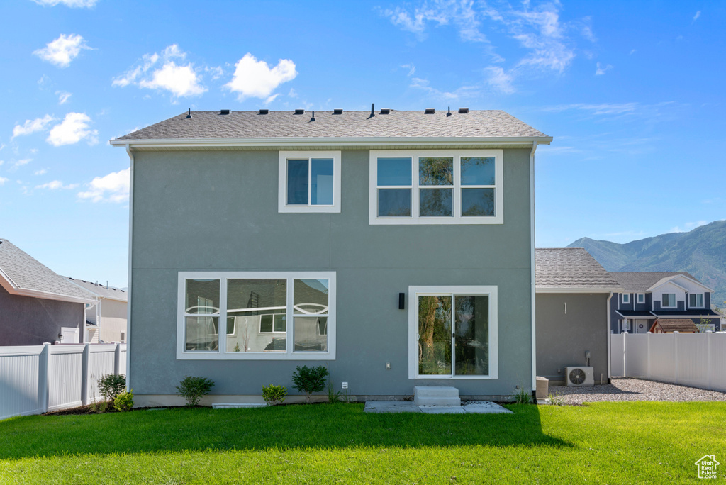Rear view of property with stucco siding and ac unit