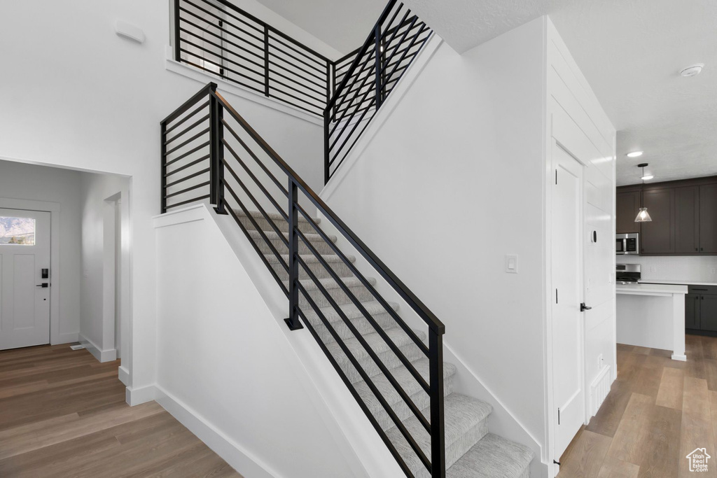 Stairs featuring wood finished floors, baseboards, and recessed lighting