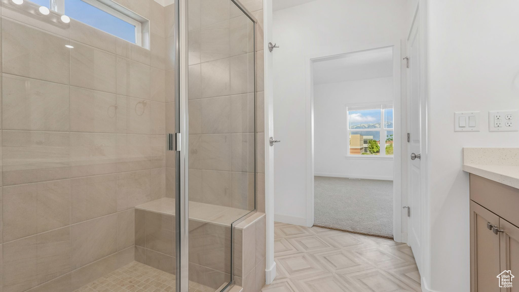 Full bath featuring vanity, plenty of natural light, a shower stall, and baseboards