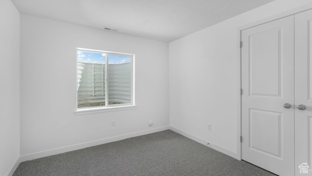 Unfurnished room featuring carpet floors and baseboards