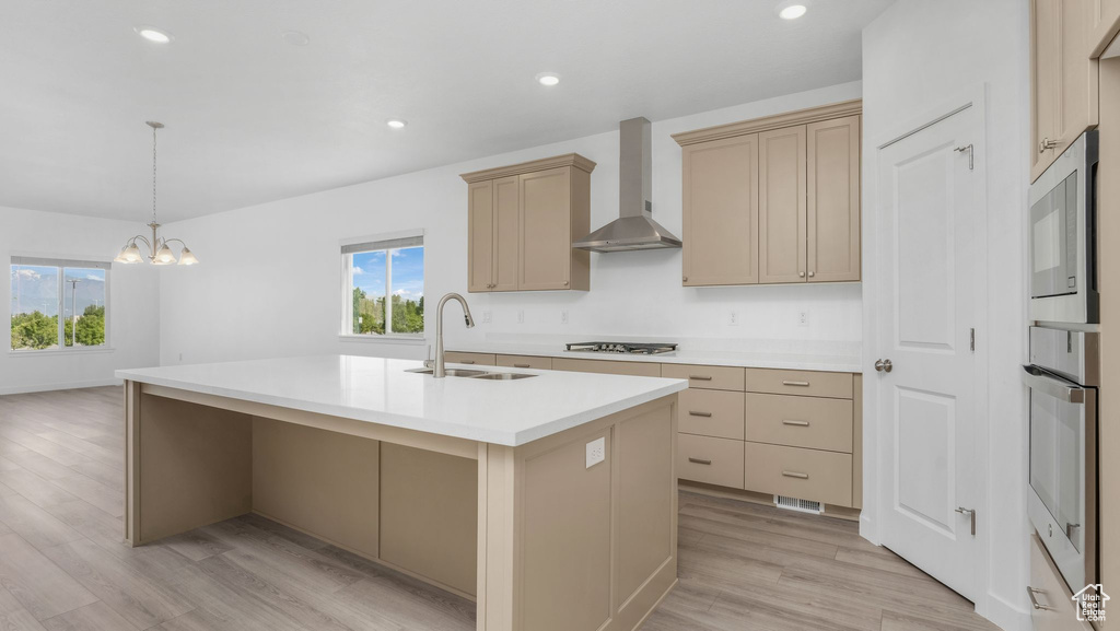 Kitchen with wall chimney exhaust hood, a sink, healthy amount of natural light, stainless steel appliances, and recessed lighting