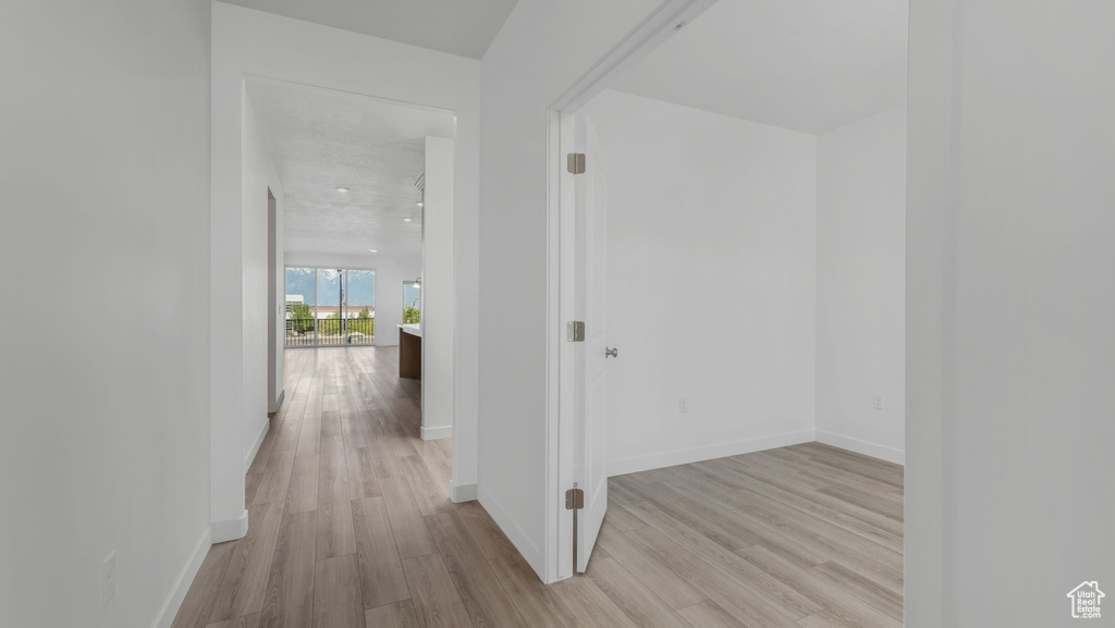 Corridor with light wood-style floors and baseboards