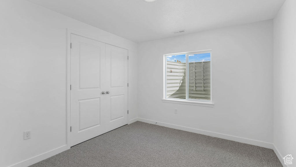 Unfurnished bedroom with carpet and baseboards