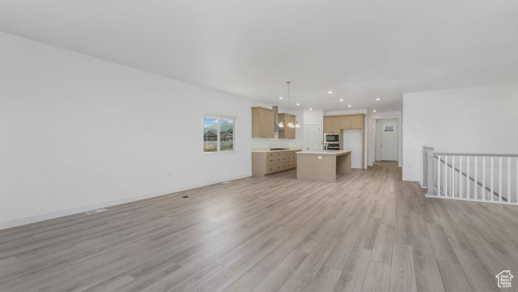 Unfurnished living room with light wood-style flooring, recessed lighting, and baseboards