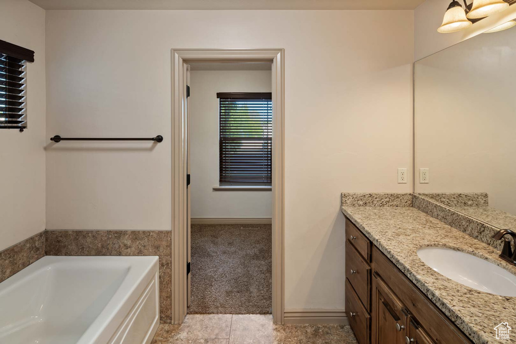 Bathroom featuring vanity, a garden tub, and tile patterned floors