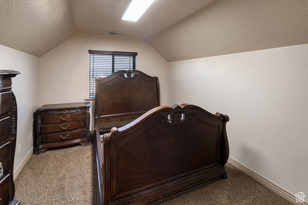 Bedroom featuring carpet, vaulted ceiling, and baseboards