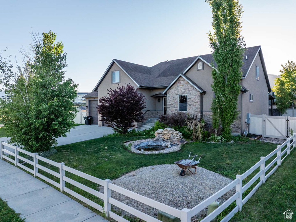 View of front of property with stucco siding, a gate, and stone siding