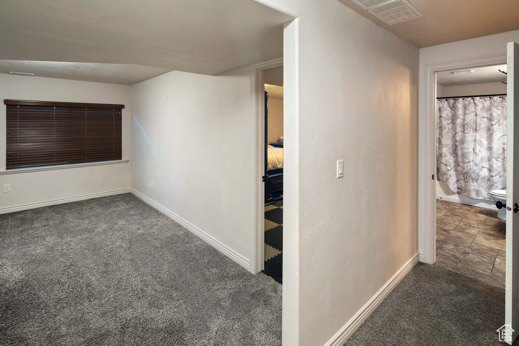 Hall featuring carpet flooring and baseboards
