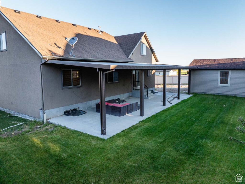 Back of property with a patio and a shingled roof
