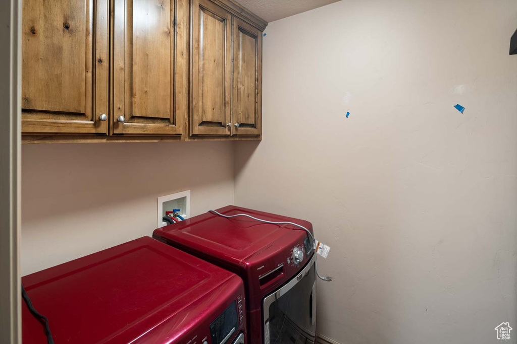 Washroom featuring cabinet space and washer / dryer