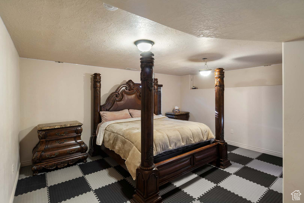 Bedroom featuring a textured ceiling and baseboards