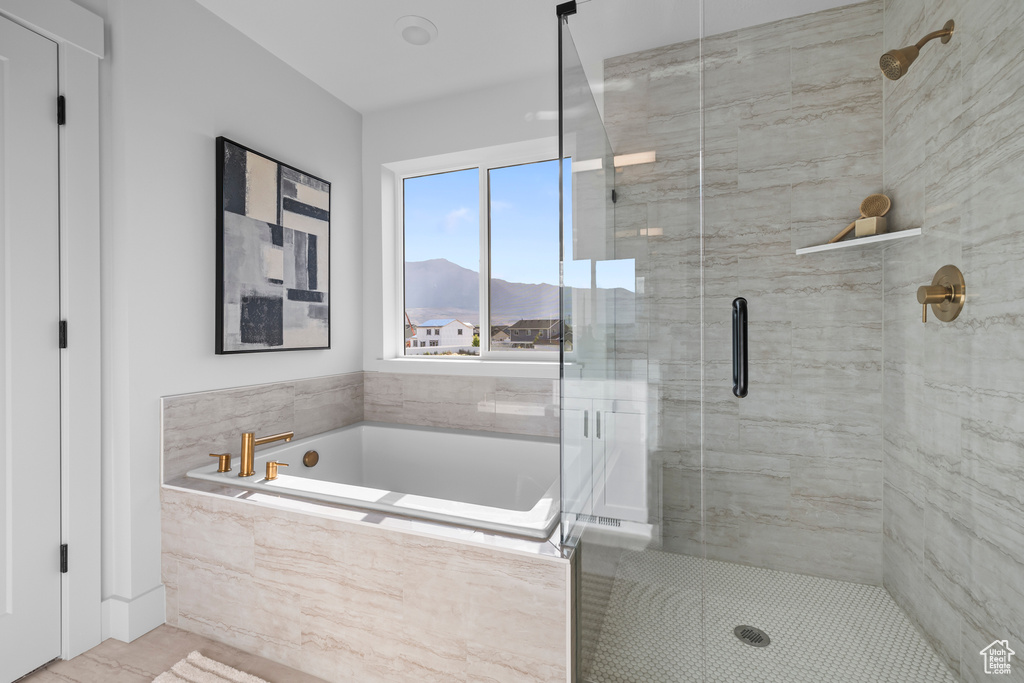 Bathroom with a shower stall, a garden tub, and a mountain view
