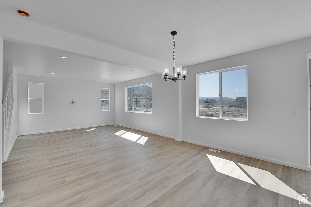 Spare room with plenty of natural light, a chandelier, baseboards, and recessed lighting