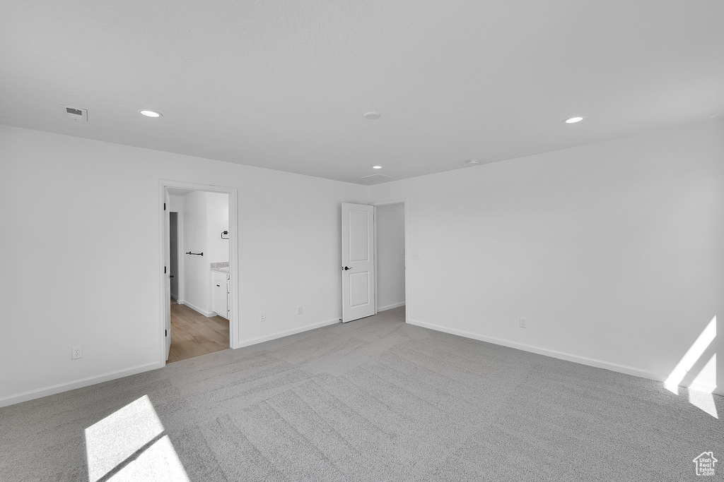 Unfurnished bedroom with carpet flooring, recessed lighting, baseboards, and ensuite bathroom