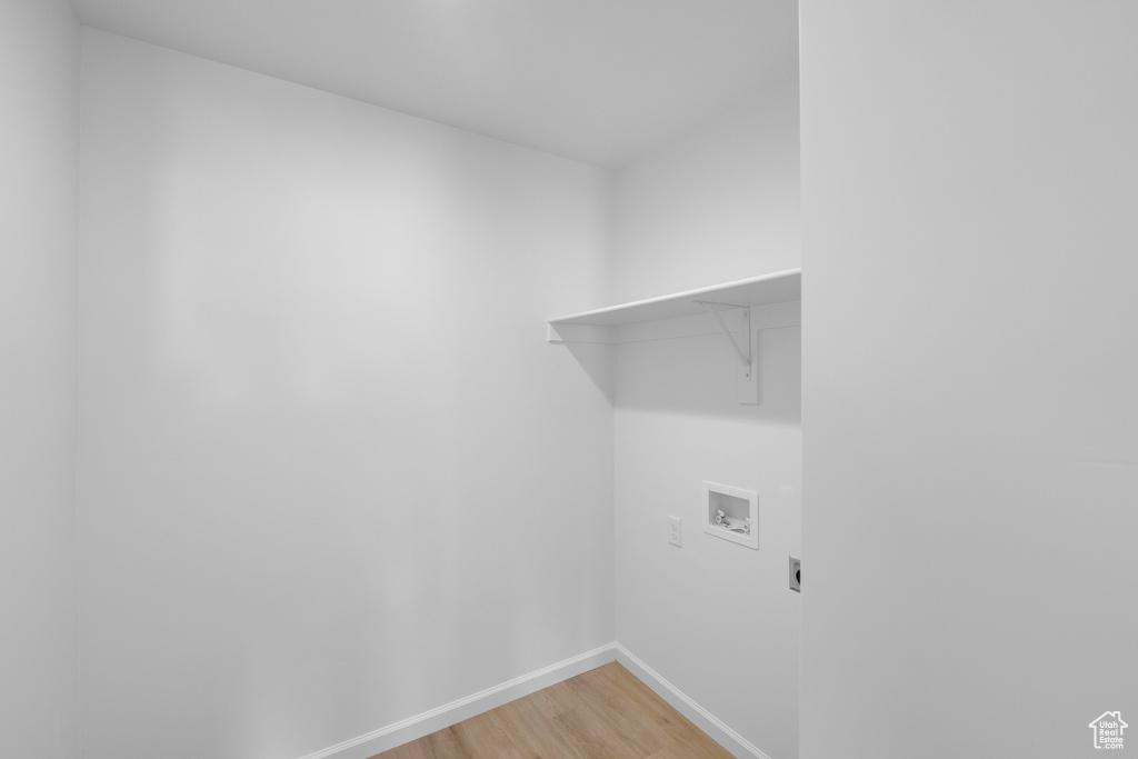 Laundry area featuring hookup for a washing machine, light wood finished floors, electric dryer hookup, and baseboards
