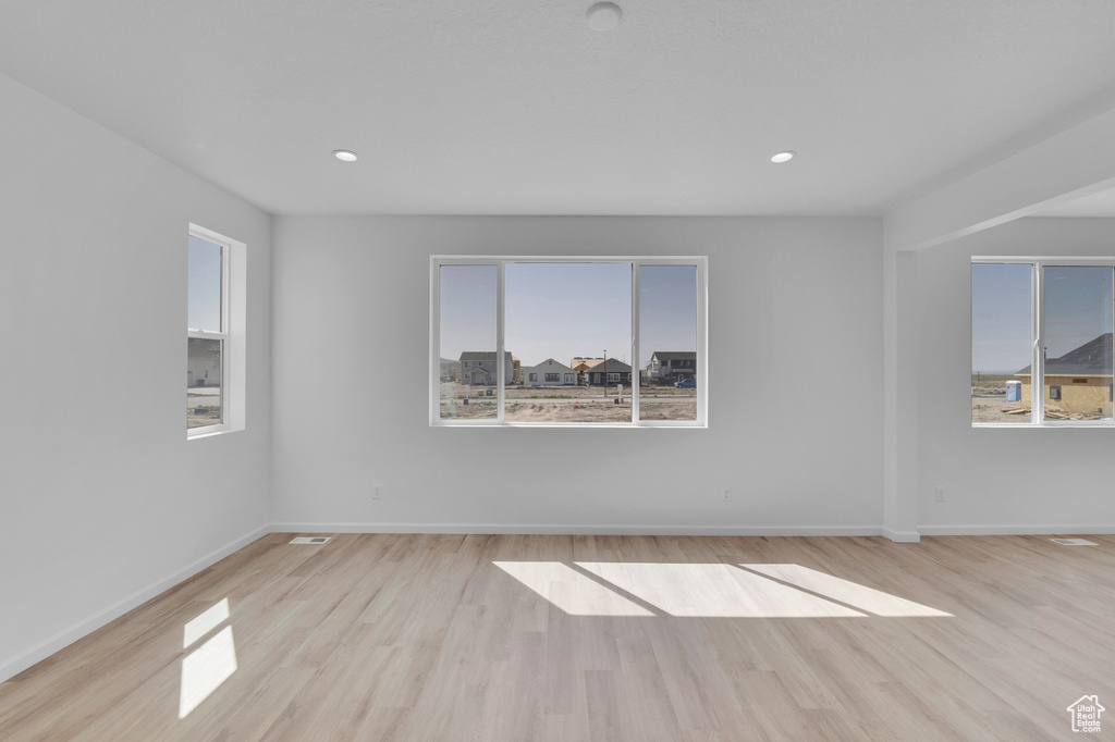 Unfurnished room with wood finished floors, baseboards, and recessed lighting