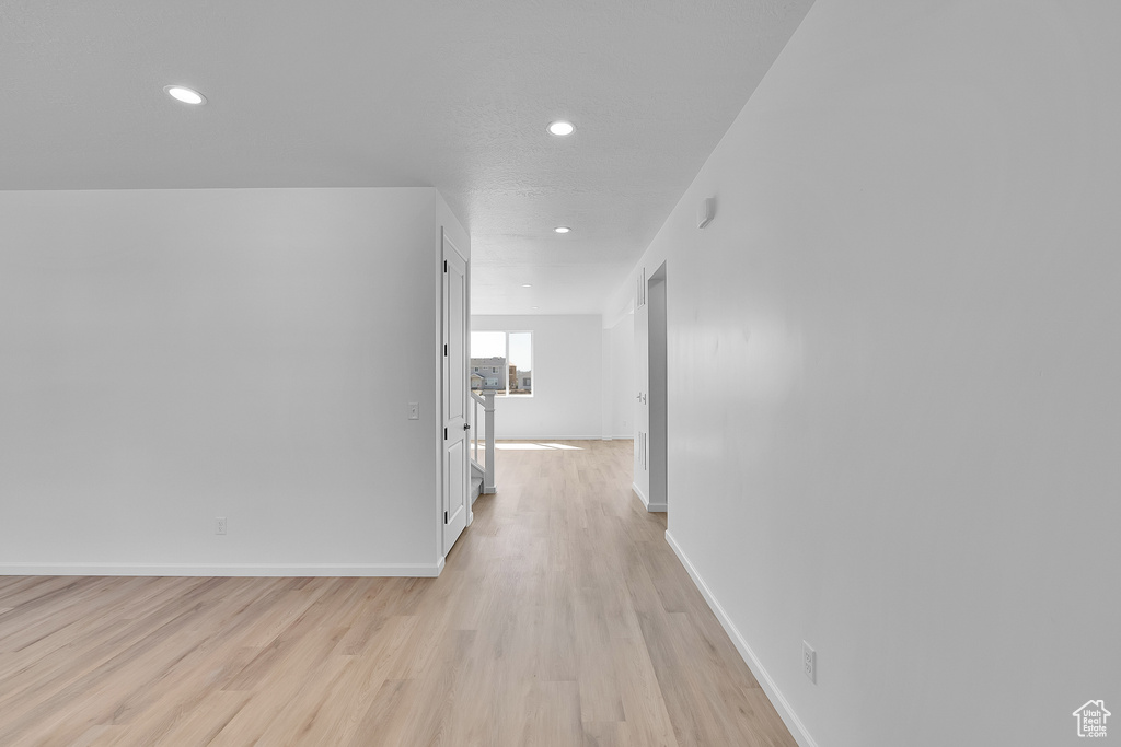Hallway featuring recessed lighting, light wood-type flooring, and baseboards