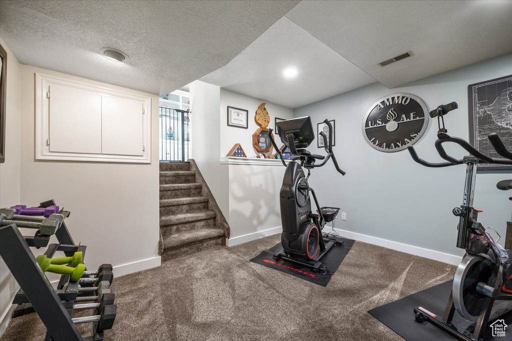 Exercise area with baseboards and a textured ceiling
