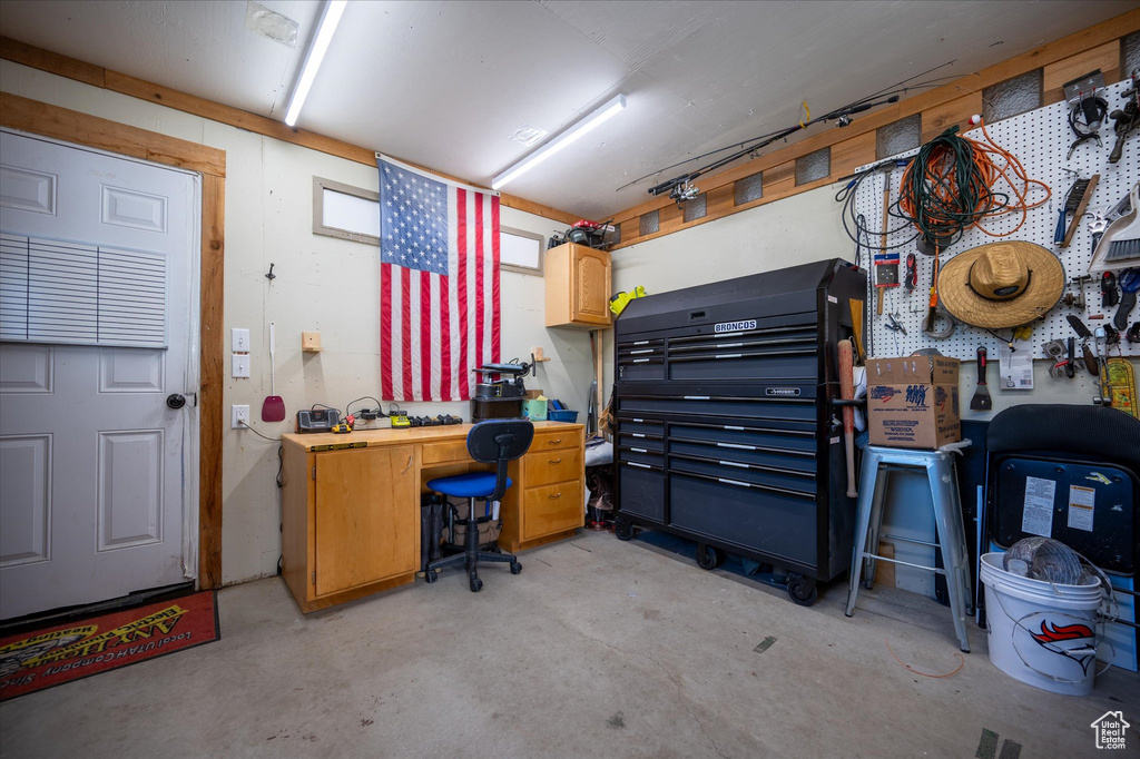 Home office featuring concrete flooring and a workshop area