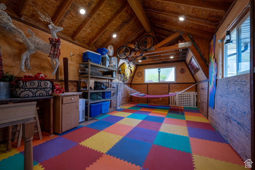 Recreation room featuring tile patterned floors and vaulted ceiling