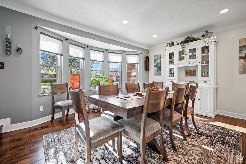 Dining area with ornamental molding, baseboards, wood finished floors, and recessed lighting