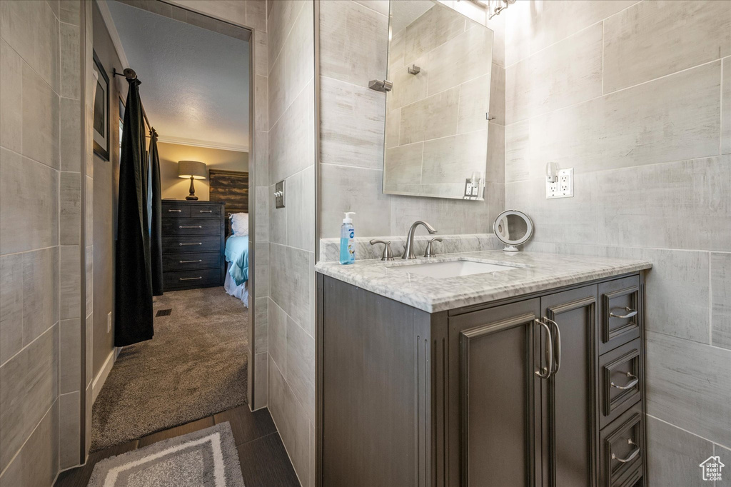 Bathroom featuring vanity, tile walls, and connected bathroom