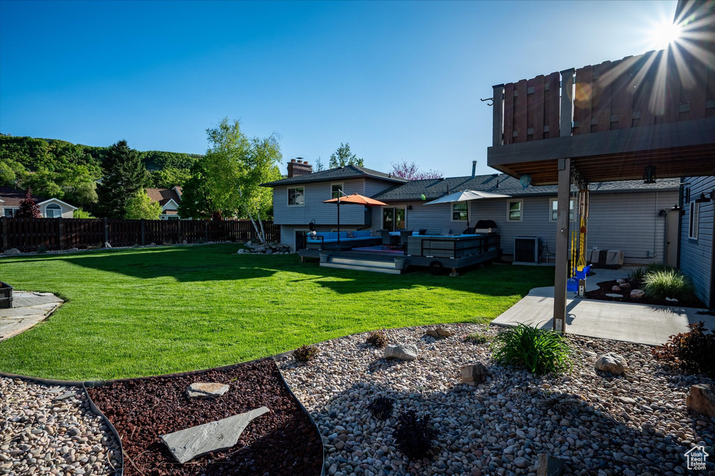 View of yard with a patio, a deck, and central AC