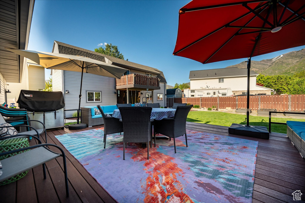 Wooden deck featuring grilling area, outdoor dining space, and an outdoor hangout area