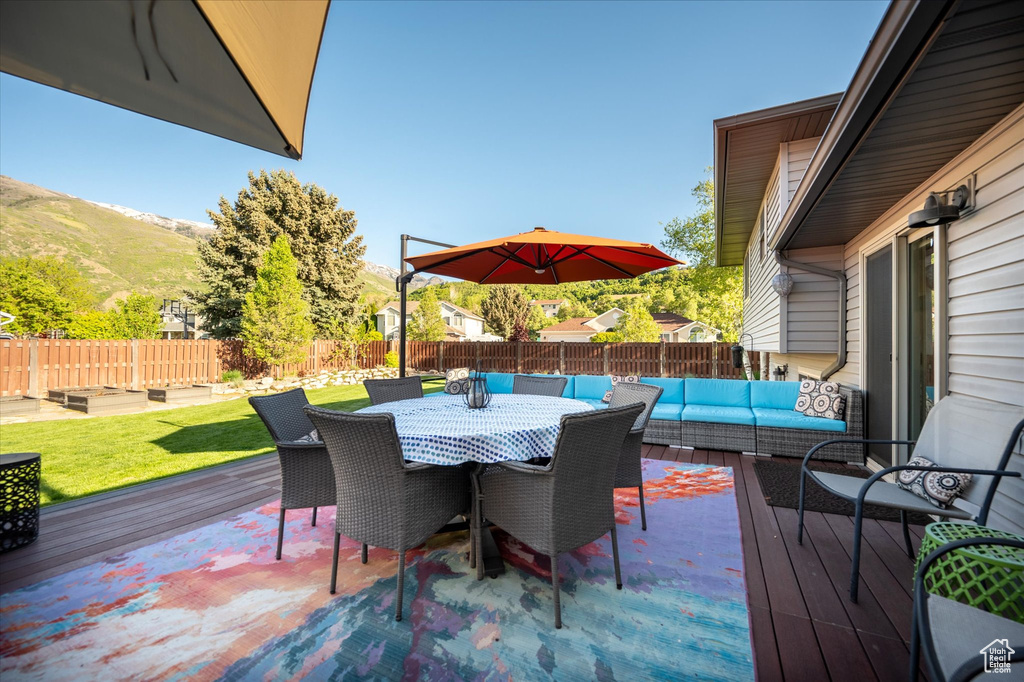 Deck featuring an outdoor living space, a mountain view, and outdoor dining space
