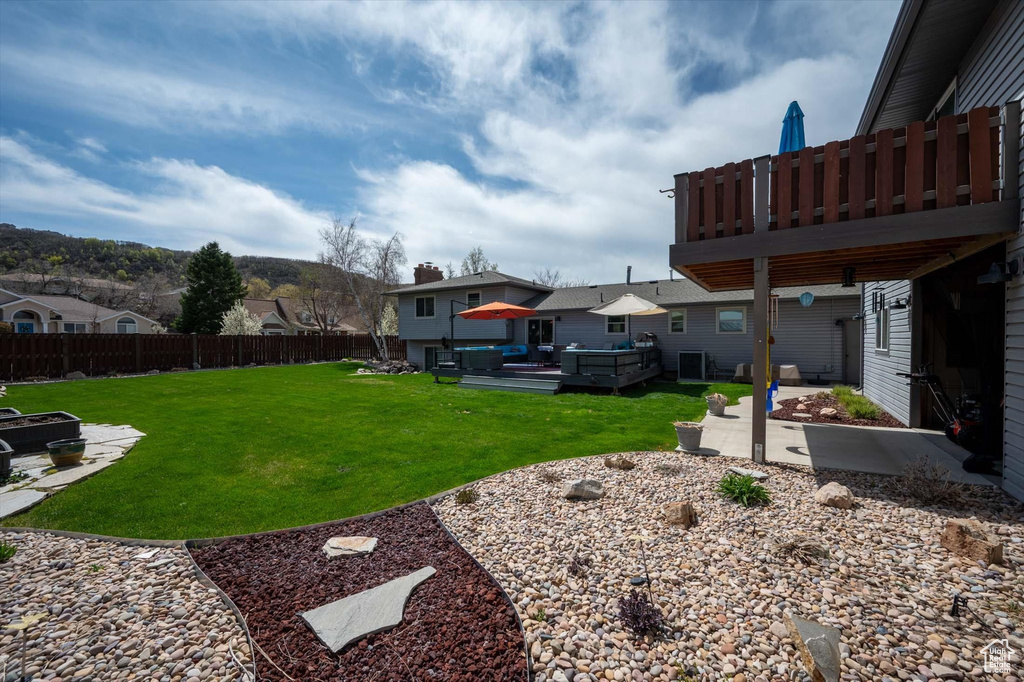 View of yard with a patio area, a residential view, a wooden deck, and a jacuzzi