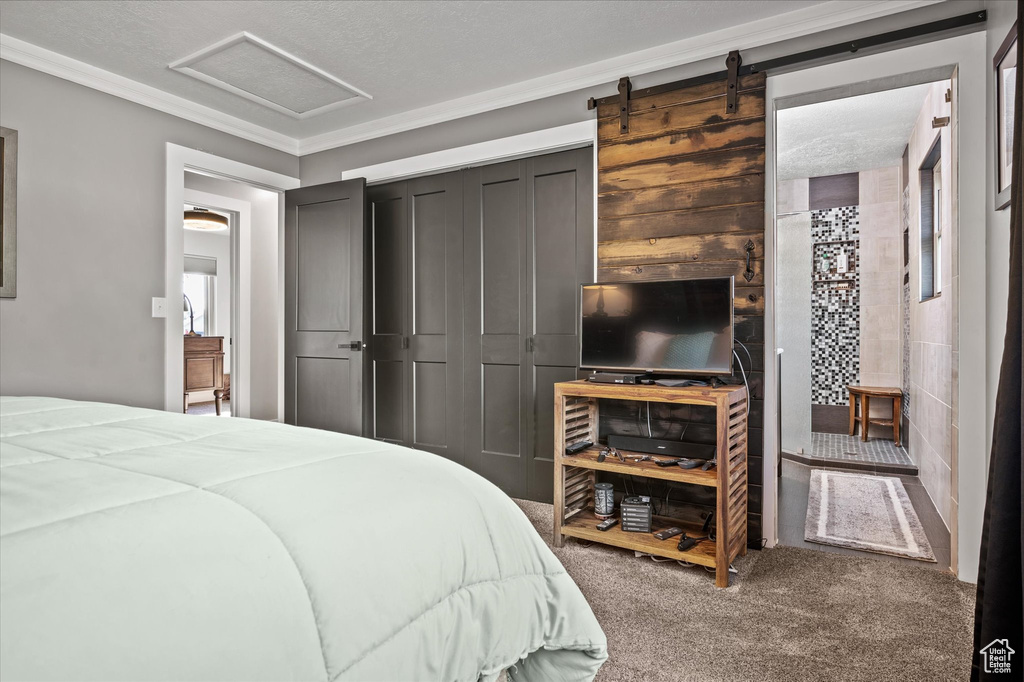Carpeted bedroom with attic access and crown molding