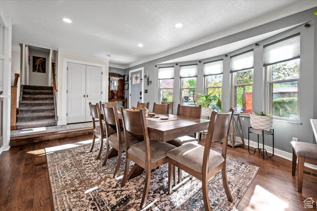 Dining space featuring crown molding, baseboards, wood finished floors, stairs, and recessed lighting