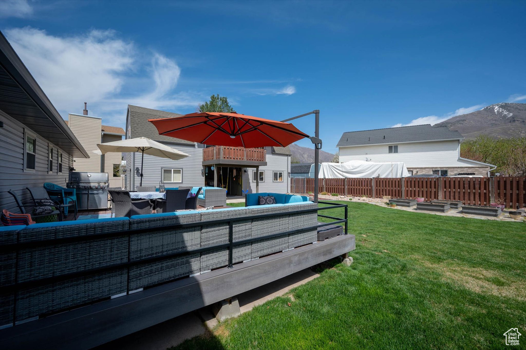 View of yard with an outdoor hangout area, a garden, and a deck with mountain view