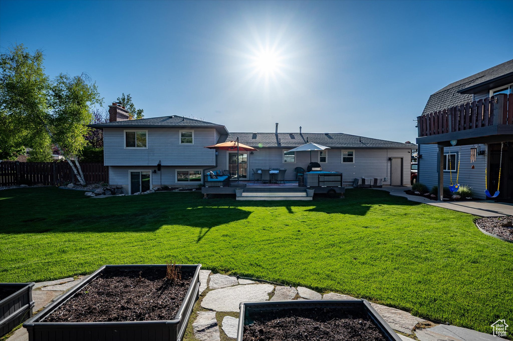 Rear view of house featuring a garden, a deck, and a chimney