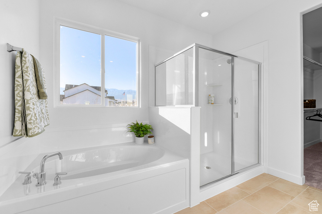 Bathroom featuring a stall shower, a garden tub, tile patterned floors, and a walk in closet