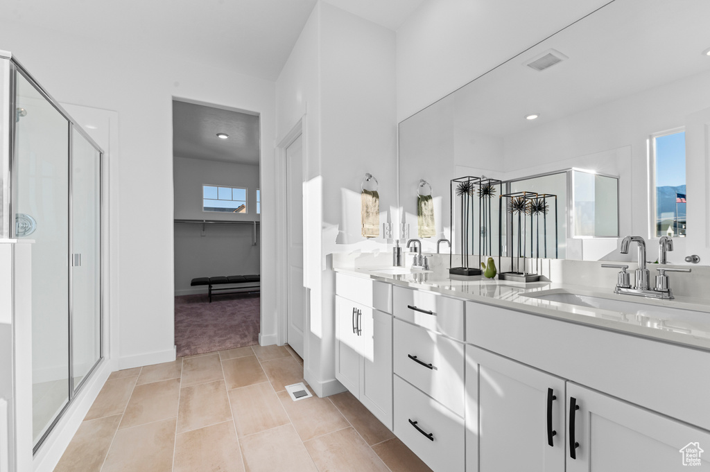 Bathroom featuring a shower stall, double vanity, recessed lighting, a spacious closet, and tile patterned floors