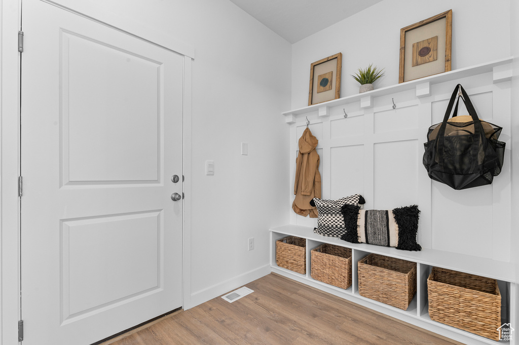 Mudroom with light wood-style flooring and baseboards