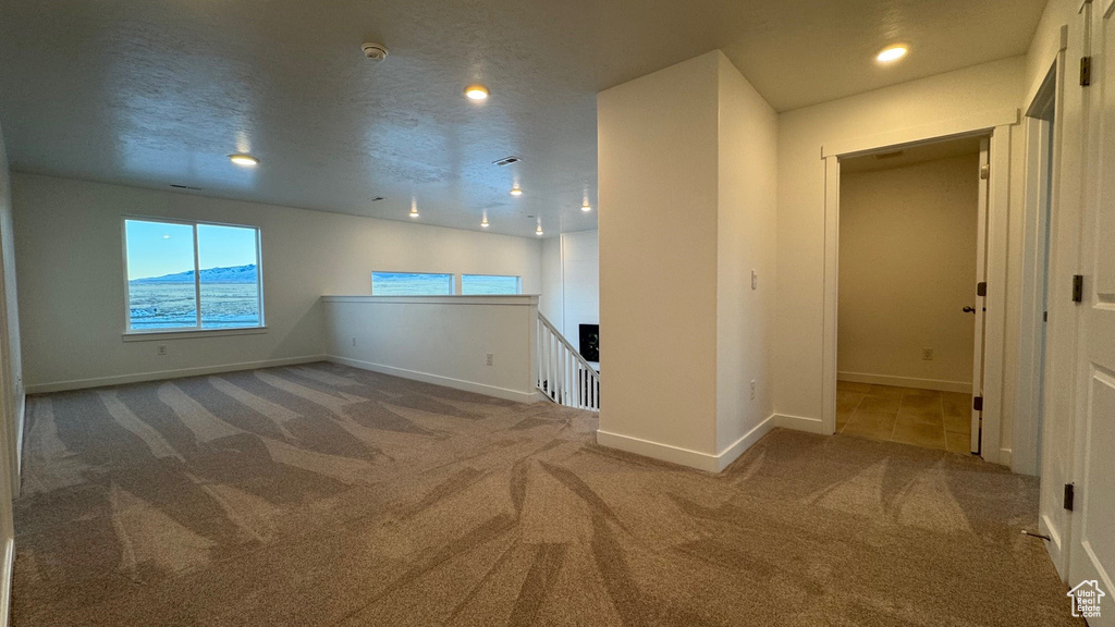 Unfurnished room featuring carpet flooring, baseboards, and recessed lighting
