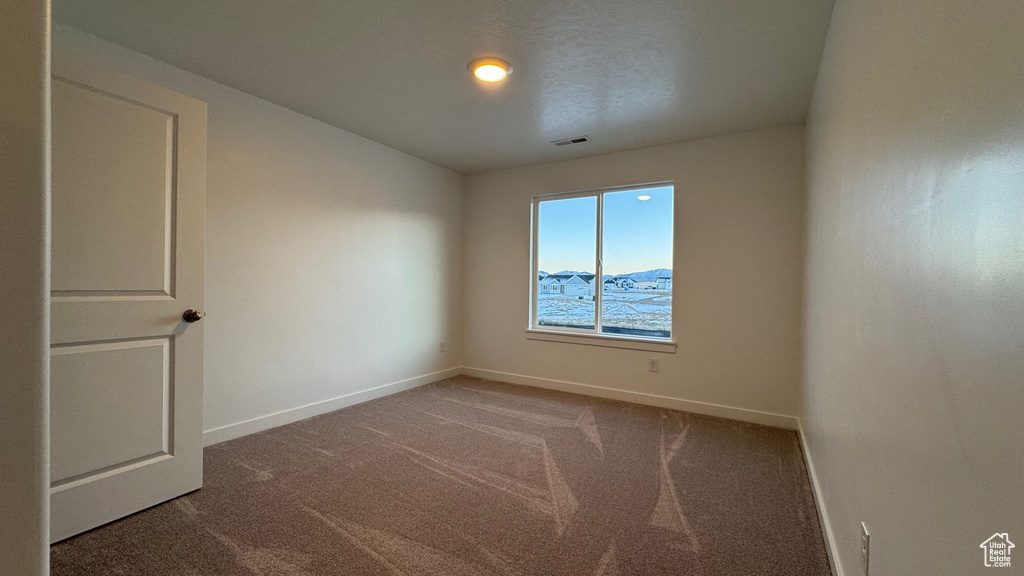 Carpeted empty room featuring baseboards