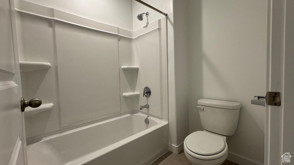 Full bath with toilet, baseboards, shower / tub combination, and tile patterned floors