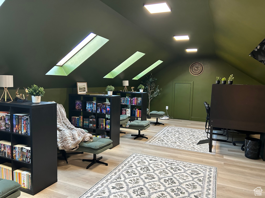 Office area with a skylight, wood finished floors, and vaulted ceiling